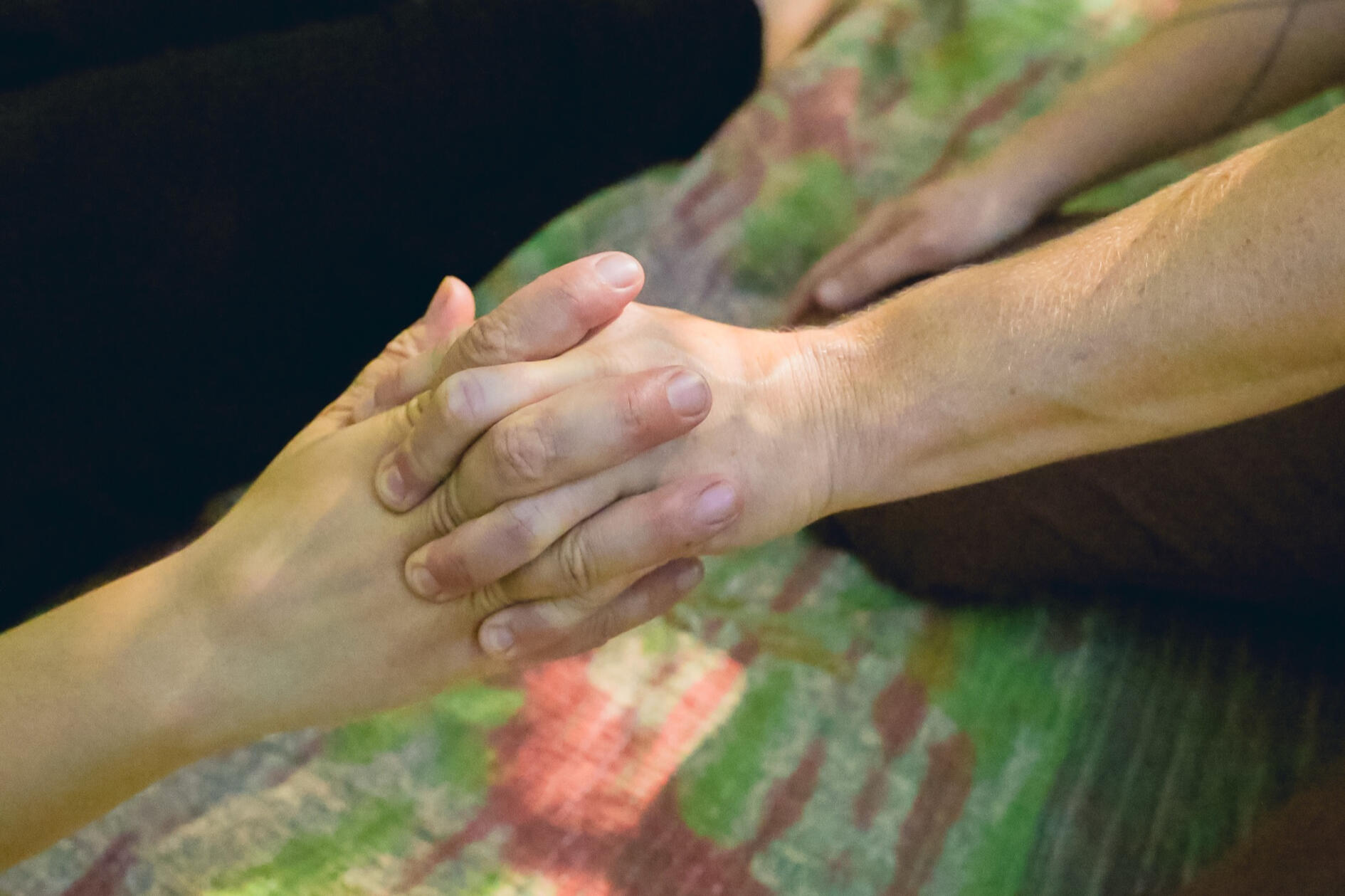 Hands in connection Hands clasped together in a moment of connection during a session